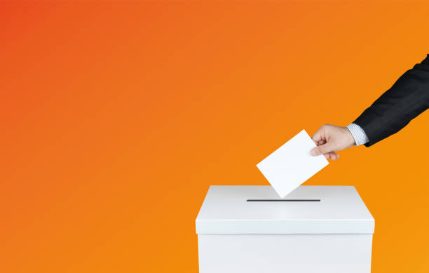 The hand of man putting his vote in the ballot box